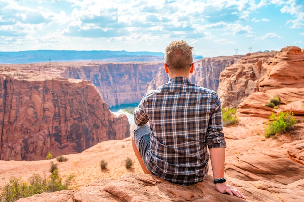 Un jeune homme admire la vue imprenable sur le barrage de Glen Canyon et le fleuve Colorado à Page Arizona