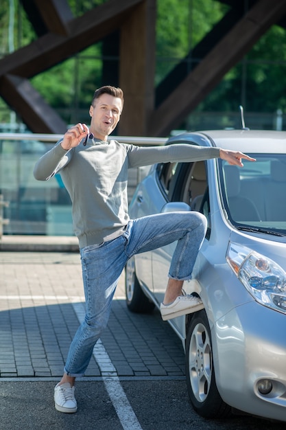 Jeune homme adulte, debout, près, a, voiture, projection, clés