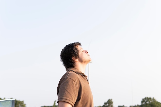 Jeune homme adulte respirant l'air frais au coucher du soleil