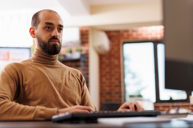 Jeune homme d'affaires adulte analysant les rapports budgétaires tout en recherchant des plans d'affaires. Chef de projet d'une entreprise Fintech développant une technologie financière et une stratégie marketing pendant son mandat.