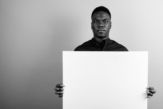 Jeune Homme D'affaires Africain Contre Le Mur Blanc. Noir Et Blanc