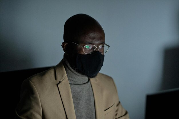 Jeune homme d'affaires africain en masque de protection et lunettes