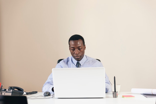 Jeune homme d'affaires africain travaillant au bureau.