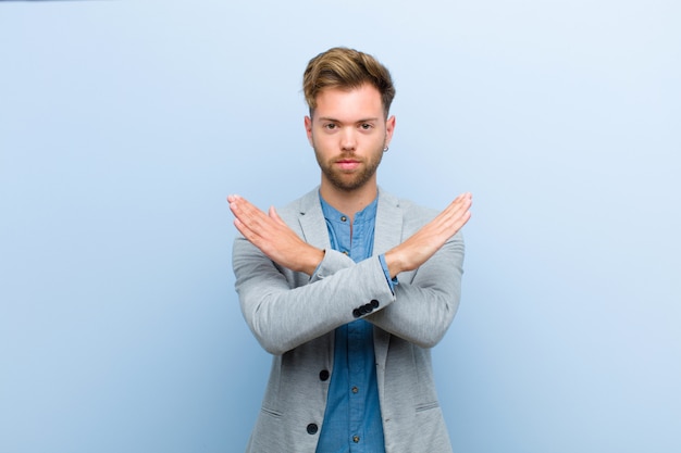 Jeune Homme D'affaires Agacé Et Fatigué De Votre Attitude, Vous En Dites Assez! Les Mains Croisées Devant, Vous Demandant De Vous Arrêter Contre Le Bleu