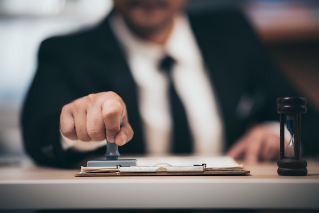 Jeune homme d'affaires apposition timbre stamper sur contrat commercial papier, prêt d'argent approuvé.