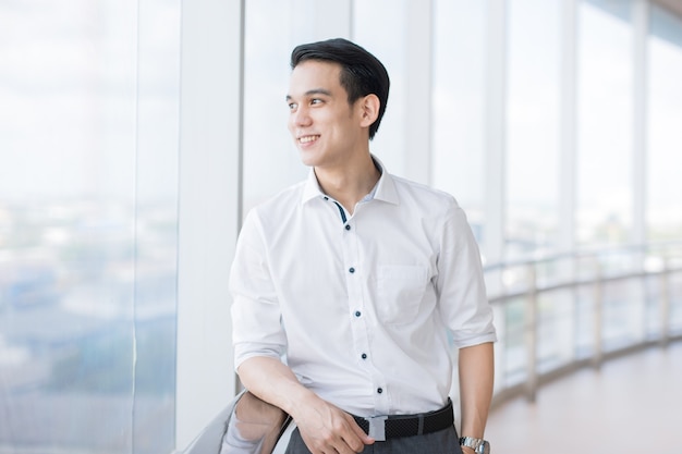 Jeune homme d'affaires asiatique à l'écart si bonheur en compagnie