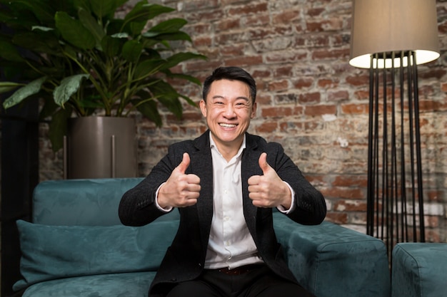 Jeune homme d'affaires asiatique excité se sentant heureux de recevoir une nouvelle opportunité d'emploi