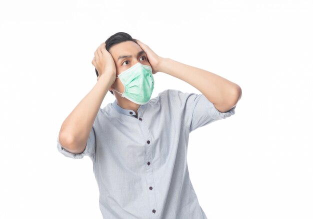 Jeune homme d'affaires asiatique en masque hygiénique choquant, 2019-nCoV ou coronavirus. Maladies respiratoires aéroportées telles que les combats de pm 2,5. Projectile studio, isolé, sur, mur blanc