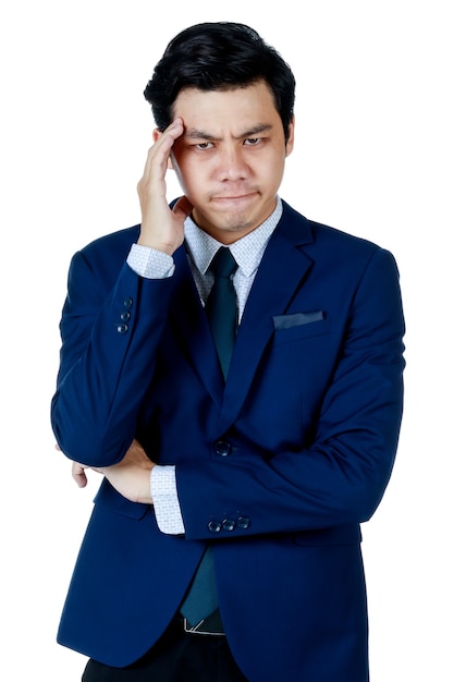 Un jeune homme d'affaires asiatique séduisant portant un costume bleu marine avec une chemise blanche et une cravate a mis sa main sur sa tête, l'air déçu et stressant. Fond blanc. Isolé