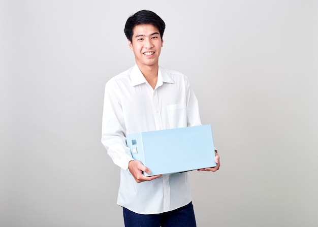 Jeune homme d'affaires asiatique tenant une boîte