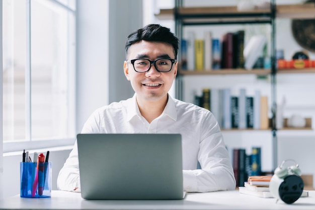 Jeune homme d'affaires asiatique travaillant au bureau