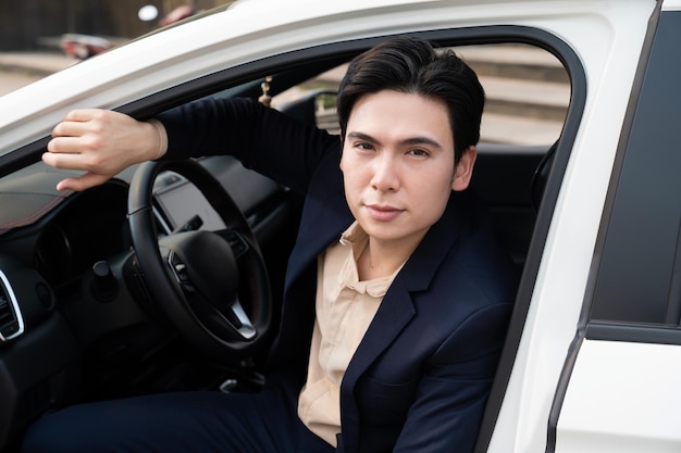 Jeune homme d'affaires asiatique avec voiture