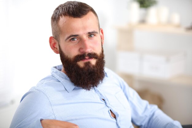 Jeune homme d'affaires assis sur une chaise au bureau