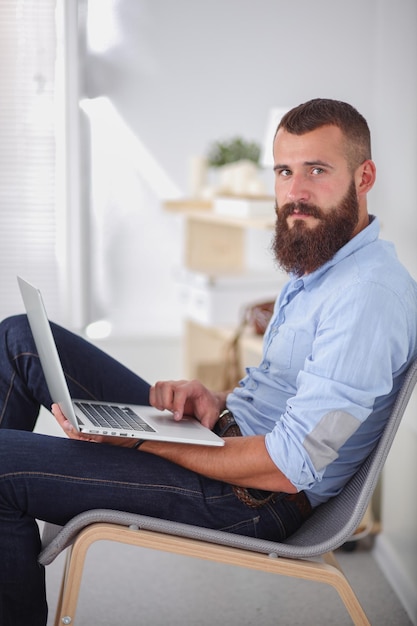 Jeune homme d'affaires assis sur une chaise au bureau