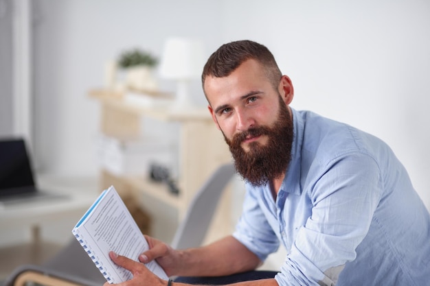 Jeune homme d'affaires assis sur une chaise au bureau