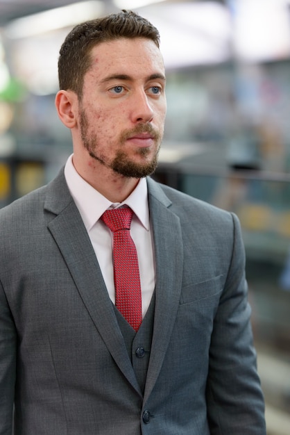 Photo jeune homme d'affaires en attente à la gare de bangkok