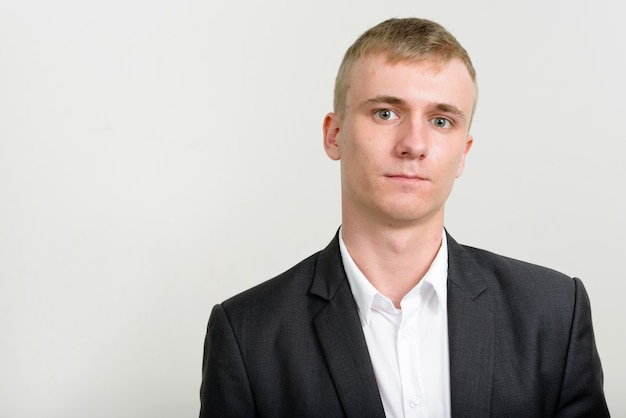 jeune homme d'affaires aux cheveux blonds portant costume sur blanc