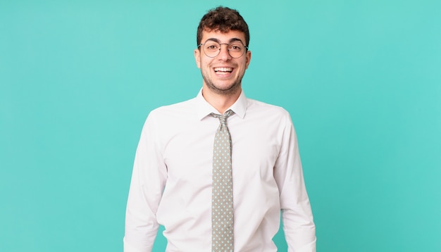 Jeune homme d'affaires ayant l'air heureux et agréablement surpris, excité par une expression fascinée et choquée