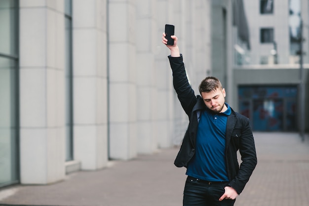 Jeune homme d'affaires avec une barbe près d'un immeuble moderne