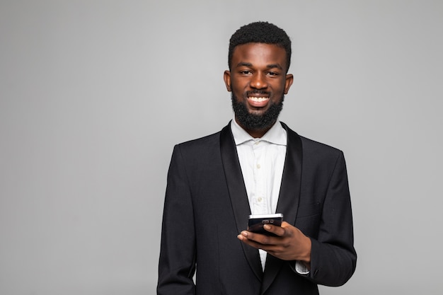 Photo jeune homme d'affaires barbu africain envoie un message texte avec son smartphone