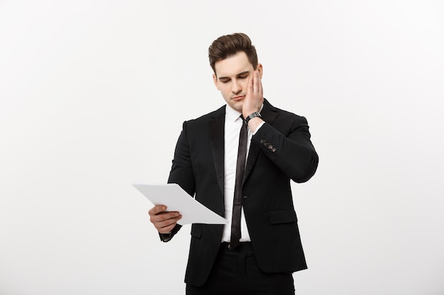 Jeune homme d'affaires beau avec un document dans ses mains isolé sur fond blanc.