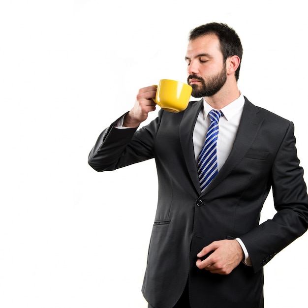 Jeune homme d&#39;affaires, boire un café sur fond blanc
