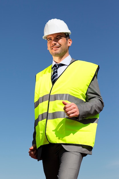 Jeune homme d'affaires avec casque et ciel bleu