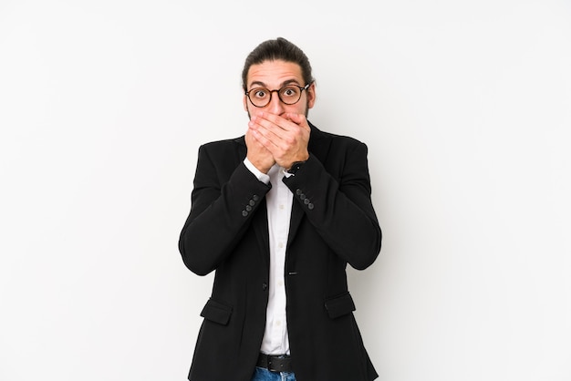 Jeune homme d'affaires caucasien isolé sur blanc bouche coning choqué avec les mains.