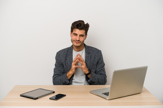 Jeune homme d'affaires caucasien travaillant avec un ordinateur portable, un téléphone portable et une tablette