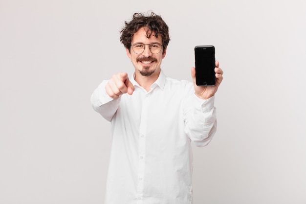 Jeune homme d'affaires avec une cellule pointant sur la caméra vous choisissant