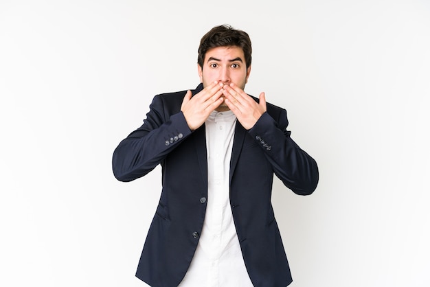 Jeune homme d'affaires choqué couvrant la bouche avec les mains.