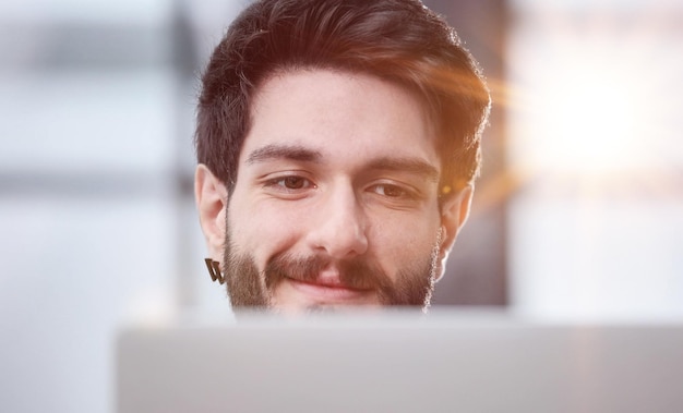 Photo un jeune homme d'affaires concentré sur un écran d'ordinateur.