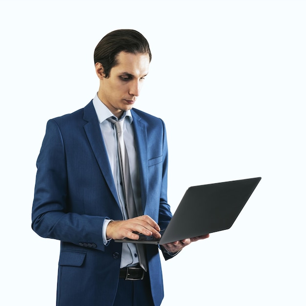 Jeune homme d'affaires en costume bleu travaillant avec un ordinateur portable moderne isolé sur fond blanc gros plan