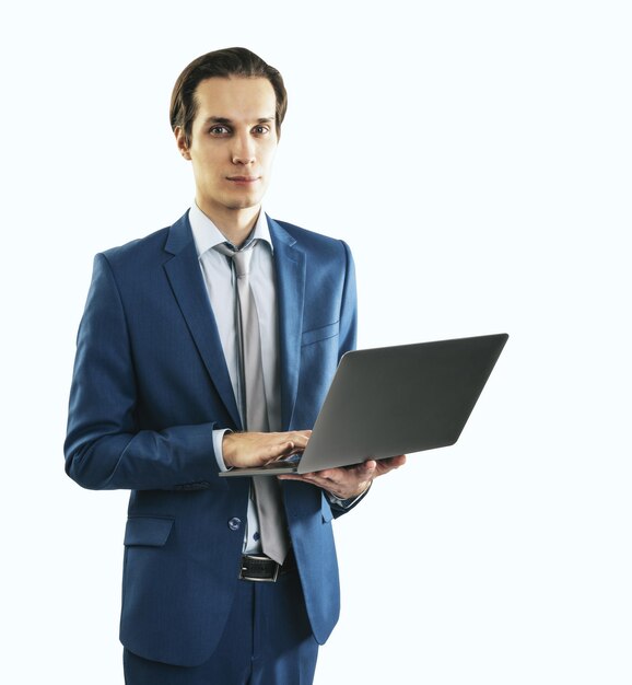 Jeune homme d'affaires en costume bleu travaillant avec un ordinateur portable moderne isolé sur fond blanc gros plan