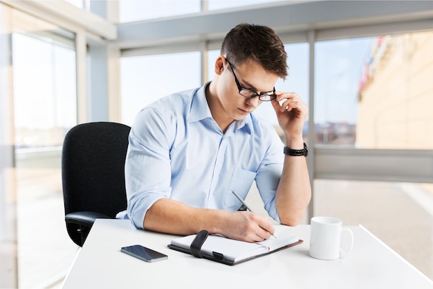 Jeune homme d'affaires en costume sur fond de bureau