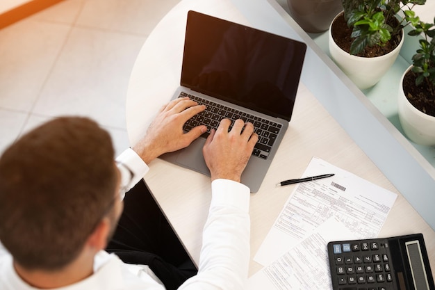 Jeune homme d'affaires en costume travaillant dans un bureau comptable