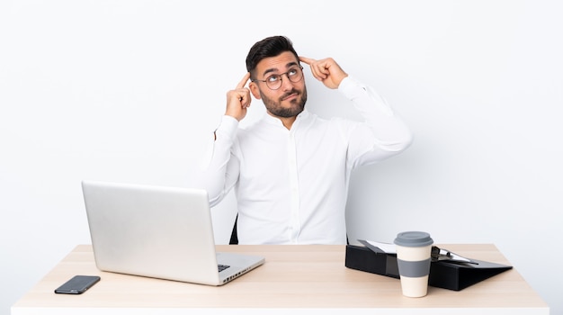 Jeune homme d'affaires dans un lieu de travail ayant des doutes et de la pensée