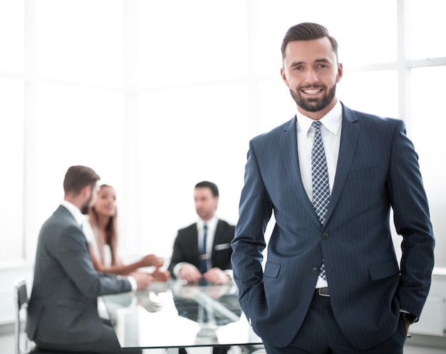 Jeune homme d'affaires debout dans un bureau lumineux