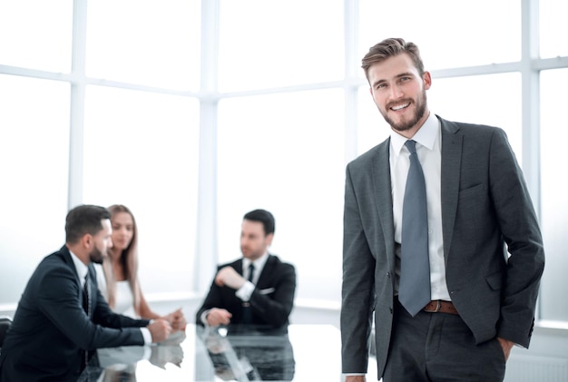 Jeune homme d'affaires debout près du bureau