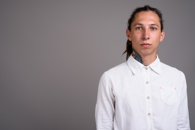 Jeune homme d'affaires avec des dreadlocks sur fond gris