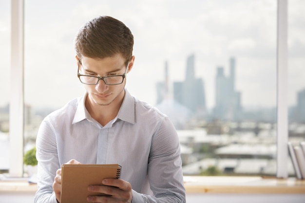 Jeune homme d'affaires écrit au bureau