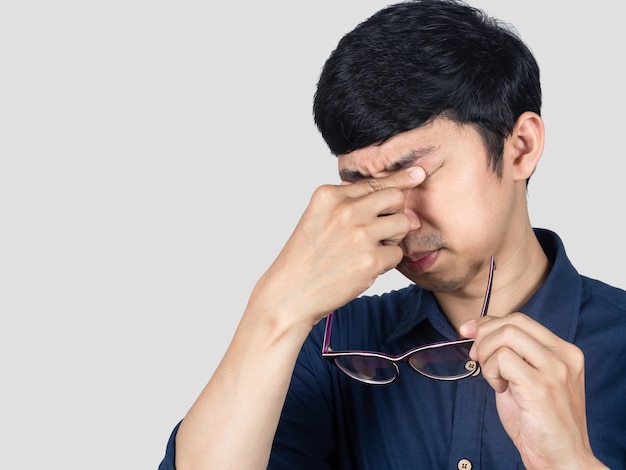 Jeune homme d'affaires a essayé de geste de travail enlever des lunettes isolées
