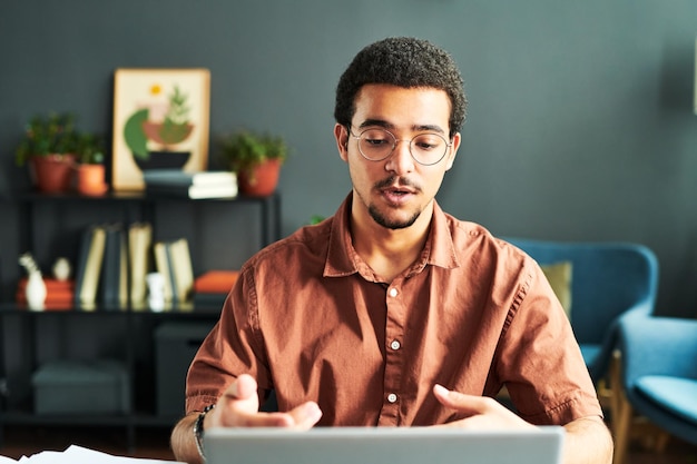 Jeune homme d'affaires ou étudiant en ligne communiquant avec un public en ligne