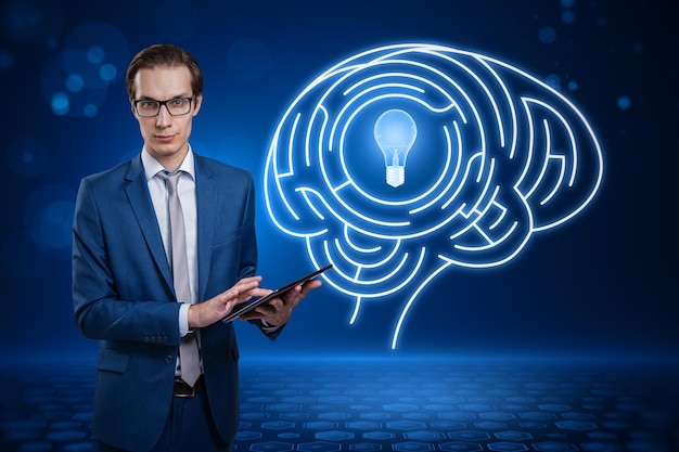 jeune homme d'affaires européen utilisant une tablette avec une ampoule numérique abstraite avec un cerveau humain