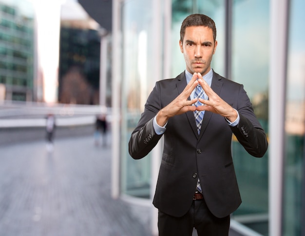 Jeune homme d&#39;affaires faisant un geste de concentration