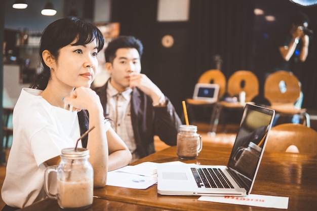 Jeune homme d&#39;affaires et femme d&#39;affaires ayant une réunion au café.