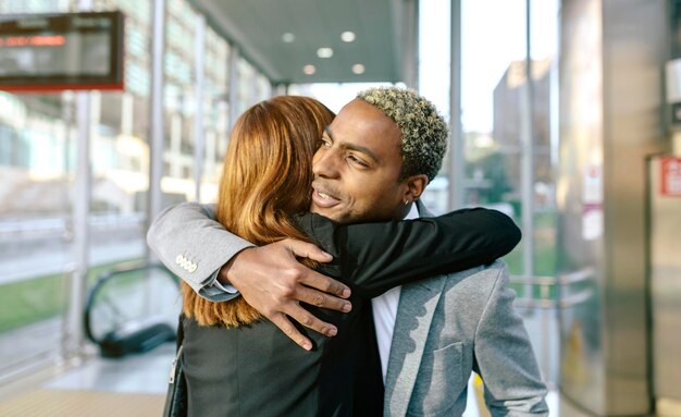 Jeune homme d'affaires et femme embrassant à la station de métro