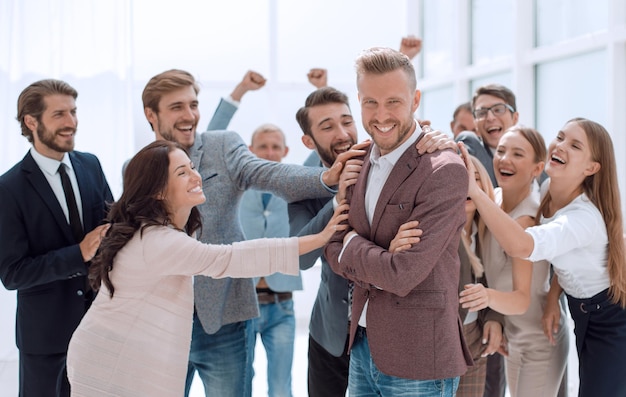 Jeune homme d'affaires sur fond d'applaudissements de l'équipe commerciale