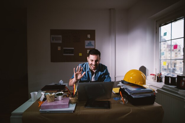 Jeune homme d'affaires heureux excité faisant des progrès pour la résolution de problèmes tout en restant après le temps de travail régulier dans le bureau sombre.