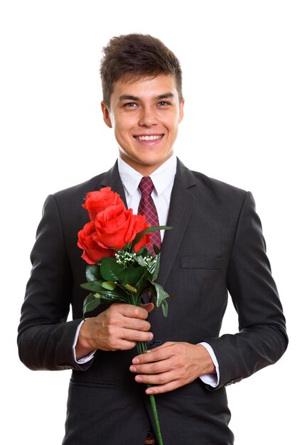 Jeune homme d'affaires heureux souriant tout en tenant des roses rouges prêtes pour la Saint-Valentin